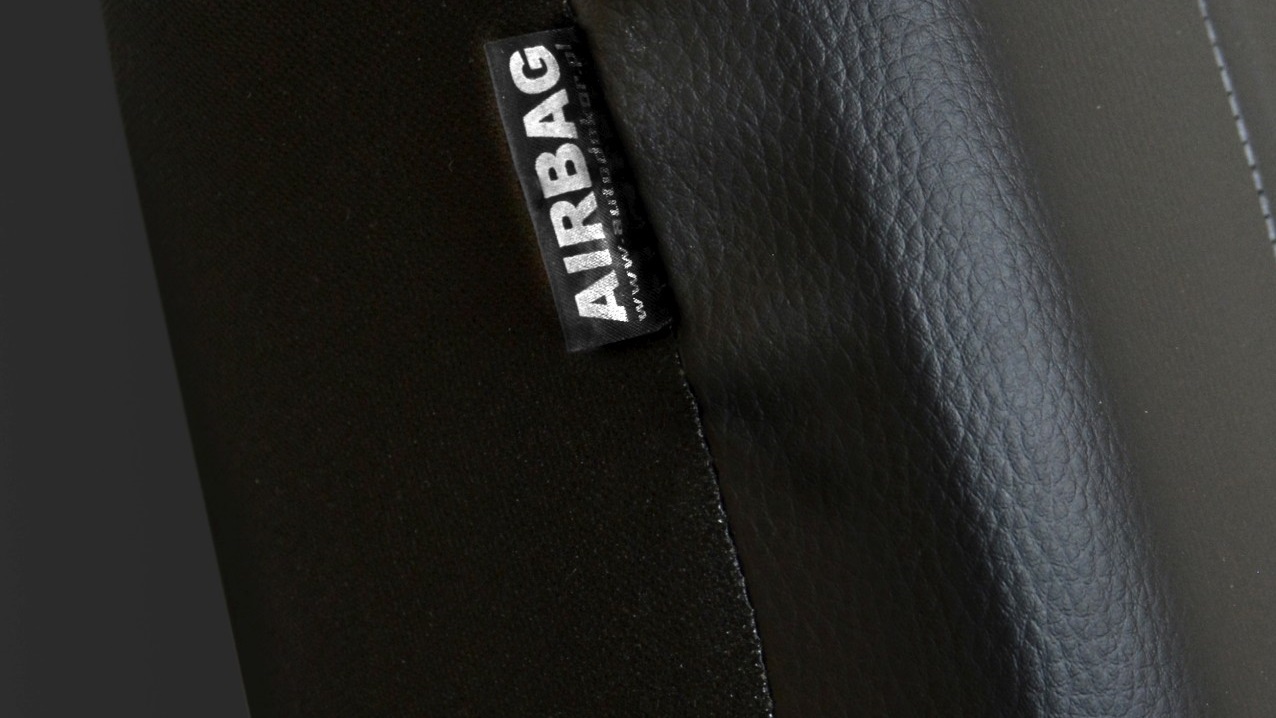 Detail certifikovaného štítku AIRBAG na boční straně černého potahu